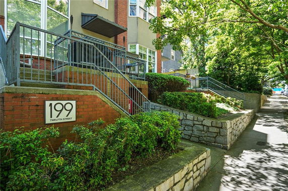 Front view of a building with brick and concrete exterior, featuring a staircase and a sign displaying the address '199 Twelfth Street'.