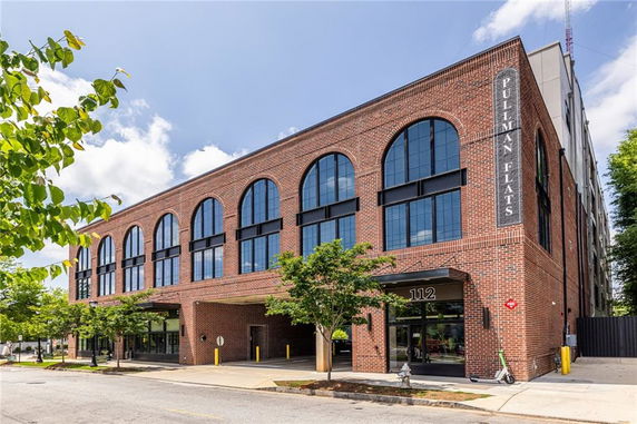 Front view of a multi-story brick building with large arched windows.