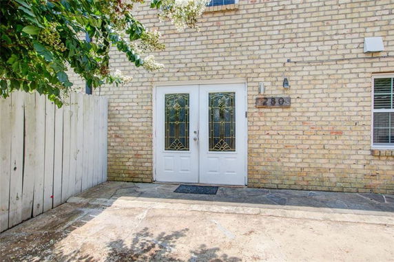 Front view of a brick building with a double glass door.