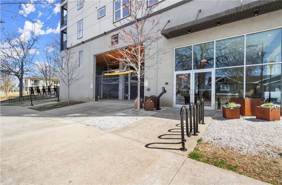 Front view of a multi-story building with large glass windows and a gated entrance.