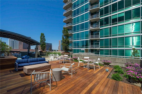 Rooftop area with seating and plants on a modern building.