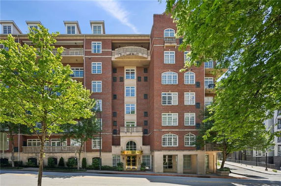 Front view of a multi-story brick building with large windows and balconies.