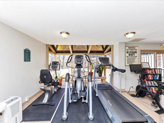 Indoor gym area with exercise machines and bookshelves.