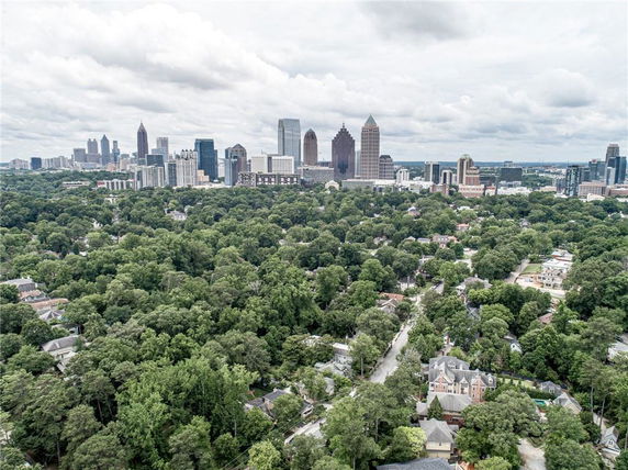 Panoramic view of a city skyline and surrounding residential areas with trees.