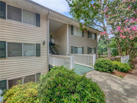 Front view of a two-story residential building with a walkway and staircase.