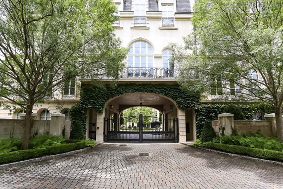 Front view of a multi-story building with arched entrance and decorative balconies.