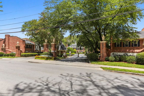 Front view of a residential estate with brick structures and decorative pillars at the entrance.