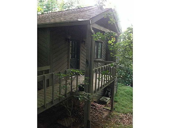 Front view of a small wooden house with a porch.