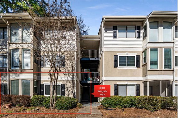 Front view of a three-story apartment building with multiple windows and central entrance.