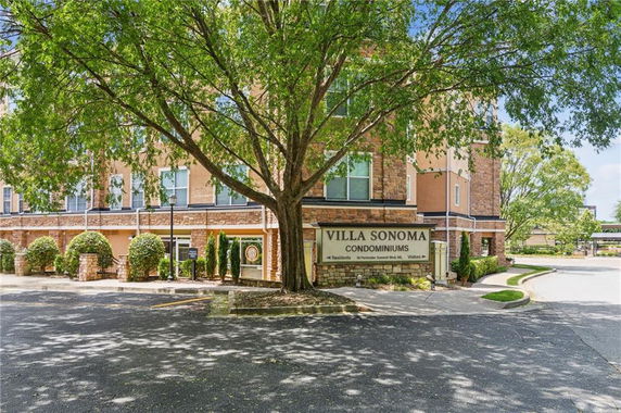 Front view of a condominium with a large tree and a sign for Villa Sonoma.