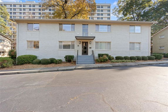 Front view of a two-story apartment building with multiple windows and a central entrance.
