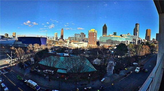 Panoramic view of a cityscape with tall buildings and clear blue sky.
