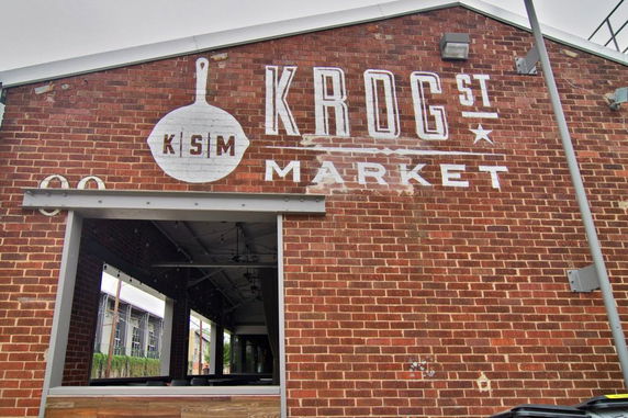 Front view of a brick market building with painted signage.