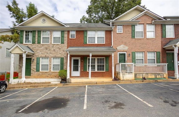 Front view of a two-story townhouse with brick and siding exterior.