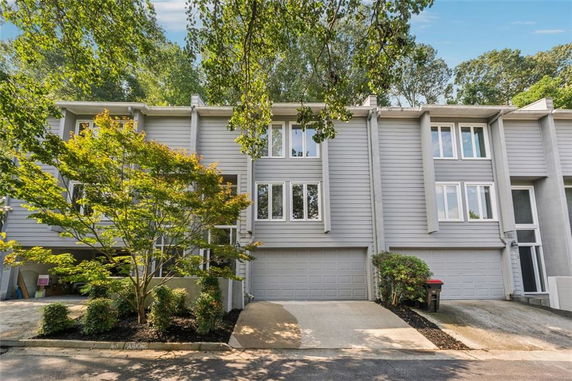 Front view of a townhouse with a garage and multiple windows.