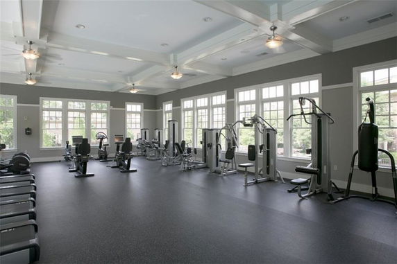 Indoor gym area with exercise equipment and large windows.