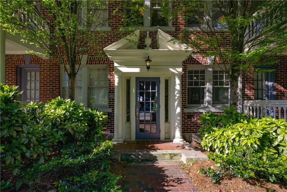 Front view of a house with a classic brick facade and decorative columns.