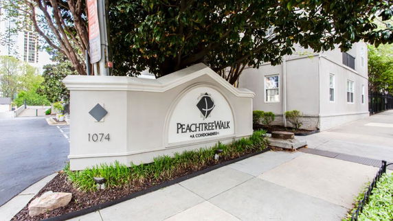 Front view of a residential condominium with sign and address.