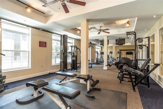 Indoor gym area with exercise equipment and large windows.