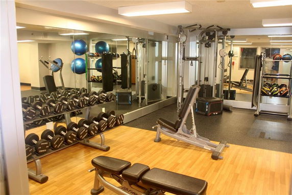 Indoor gym area with weights and exercise equipment.