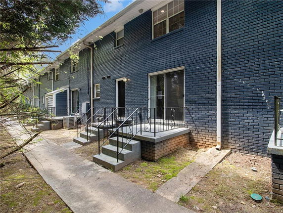 Rear view of a two-story brick building with a simple stairway.