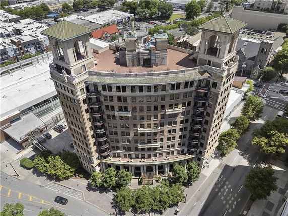 Aerial view of a multi-story building with two tower-like structures on the roof.