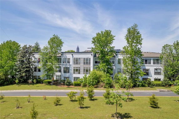 Front view of a multi-story residential building surrounded by trees.