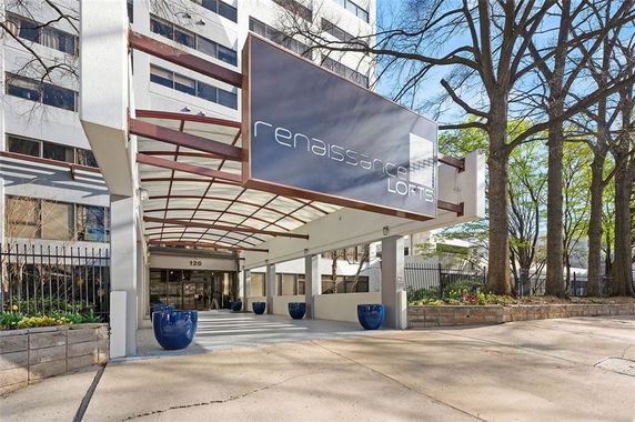 Front view of a multi-story building with a prominent entrance and signage for Renaissance Lofts.