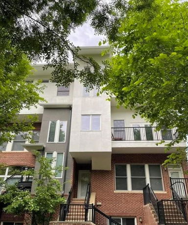 Front view of a multi-story building with brick and panel facade.