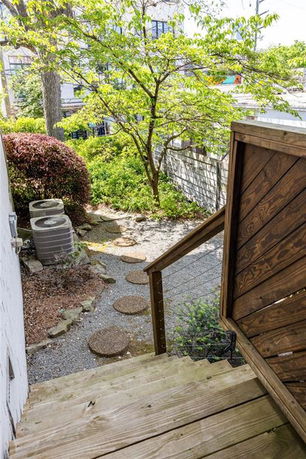 Outdoor area with wooden steps, a garden path, and greenery.