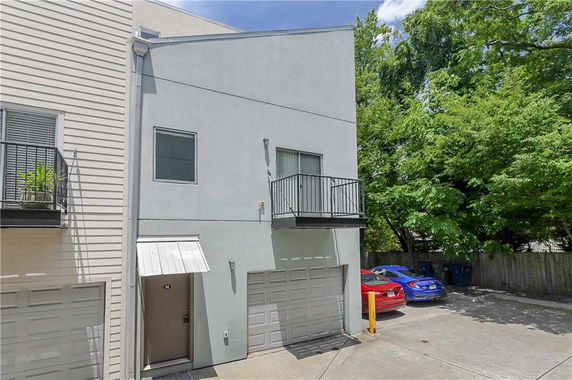 Front view of a house with a garage and a small balcony.