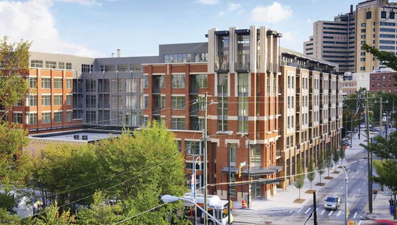 Front view of a multi-story modern building with brick and glass facade.