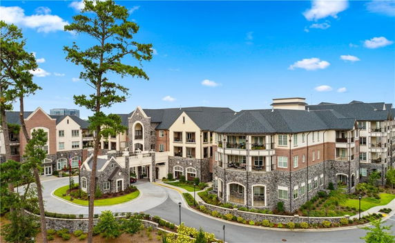 Front view of a large multi-story residential building with stone and brick facade.