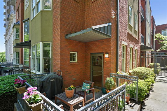 Front view of a modern multi-story townhouse with brick and stucco exterior.