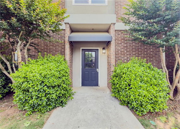 Front view of a house entrance with a black door and brick exterior.