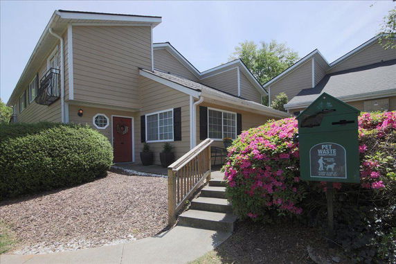 Front view of a two-story house with a red front door and a small porch.