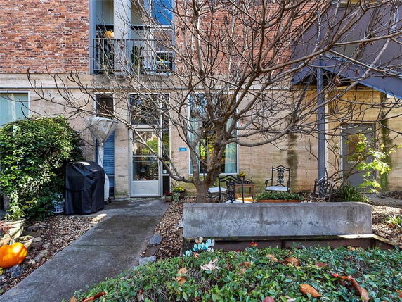 Front view of a building with brick and stone facade and an outdoor seating area.