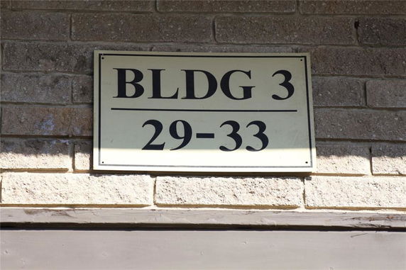 Sign on a brick wall indicating Building 3 with numbers 29-33.