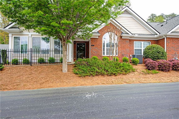 Front view of a single-story house with brick exterior and gabled roof.
