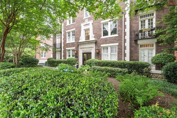 Front view of a multi-story brick building with decorative entrance and large windows.