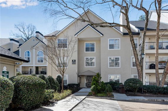 Front view of an apartment building with three floors and multiple entrances.