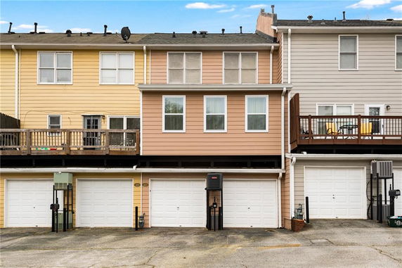 Front view of a multi-story townhouse with a garage on the ground level.