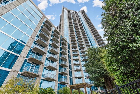 Front view of a high-rise building with multiple balconies and glass windows.