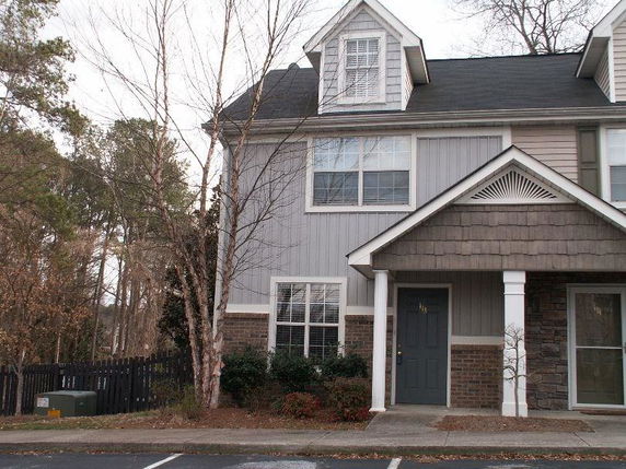 Front view of a two-story house with a gable roof and a small porch area.