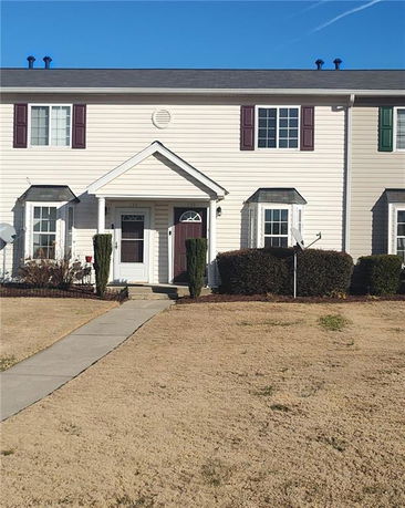 Front view of a two-story townhouse with a covered entrance.