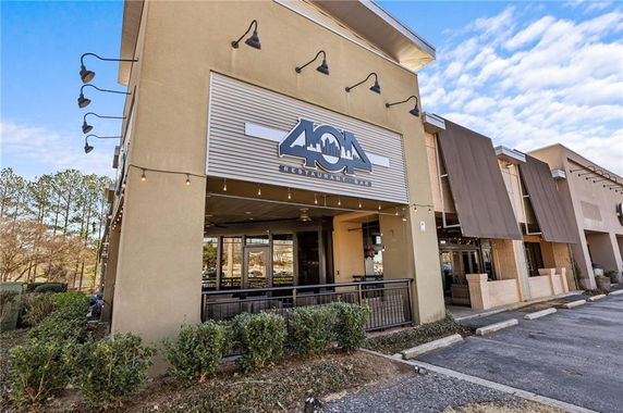 Front view of a restaurant building with signage and outdoor patio area.