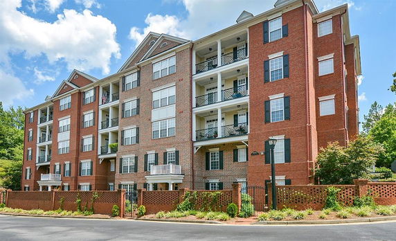 Front view of a multi-story building with brick exterior and balconies.