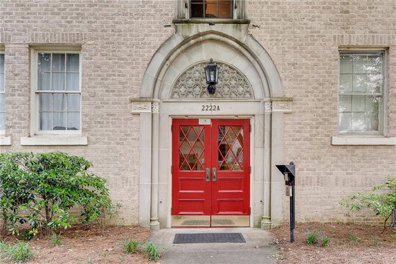 Front view of a building with a red double door entrance and brick exterior.