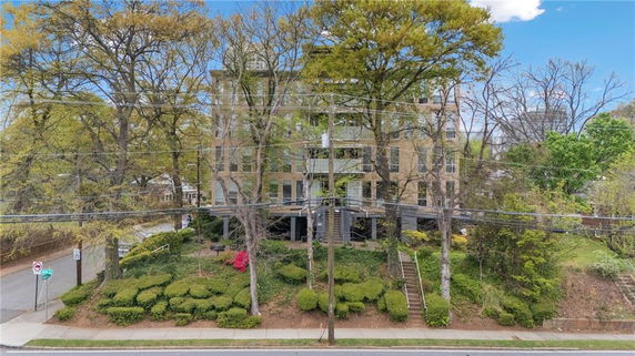 Front view of a multi-story building surrounded by trees.