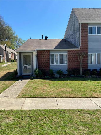 Front view of a brick single-story house with a small garden and pathway.
